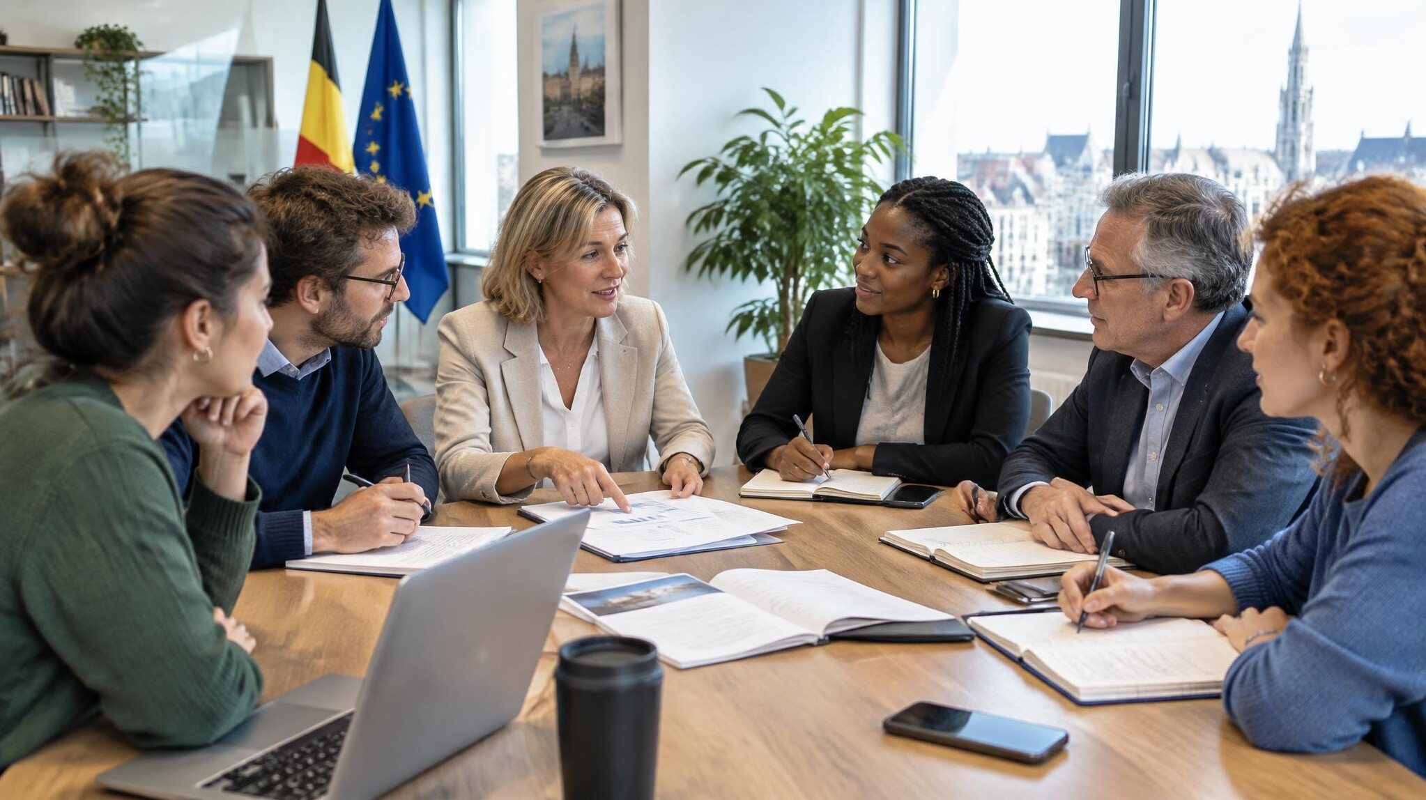 Group of colleagues discussing a project around a table in a bright office